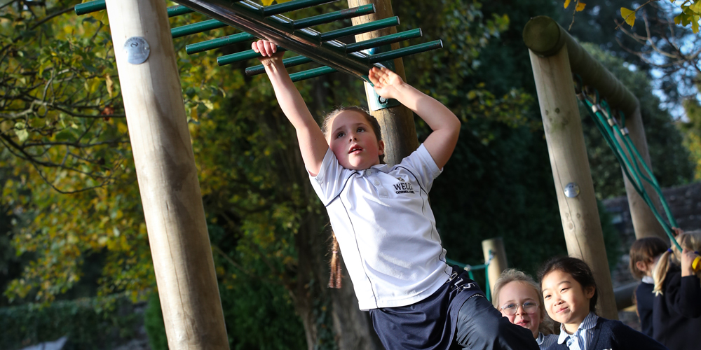Girl on the monkey bars at the Prep School in Wells, Somerset