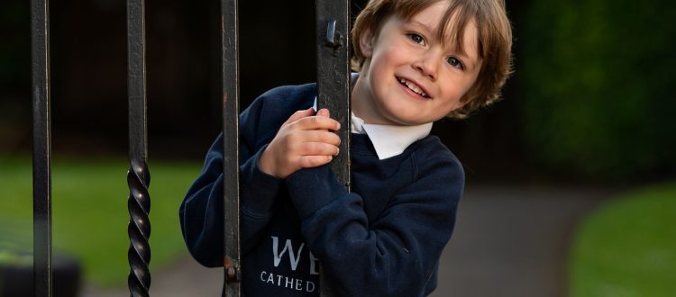 Boy outside by a gate at our Independent Pre-Prep in Wells, Somerset