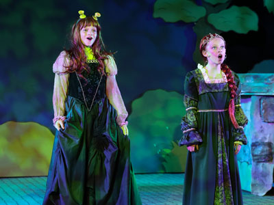 Two girls playing Fiona in Shrek (as princess and ogre) at Cedars Hall in Wells Somerset
