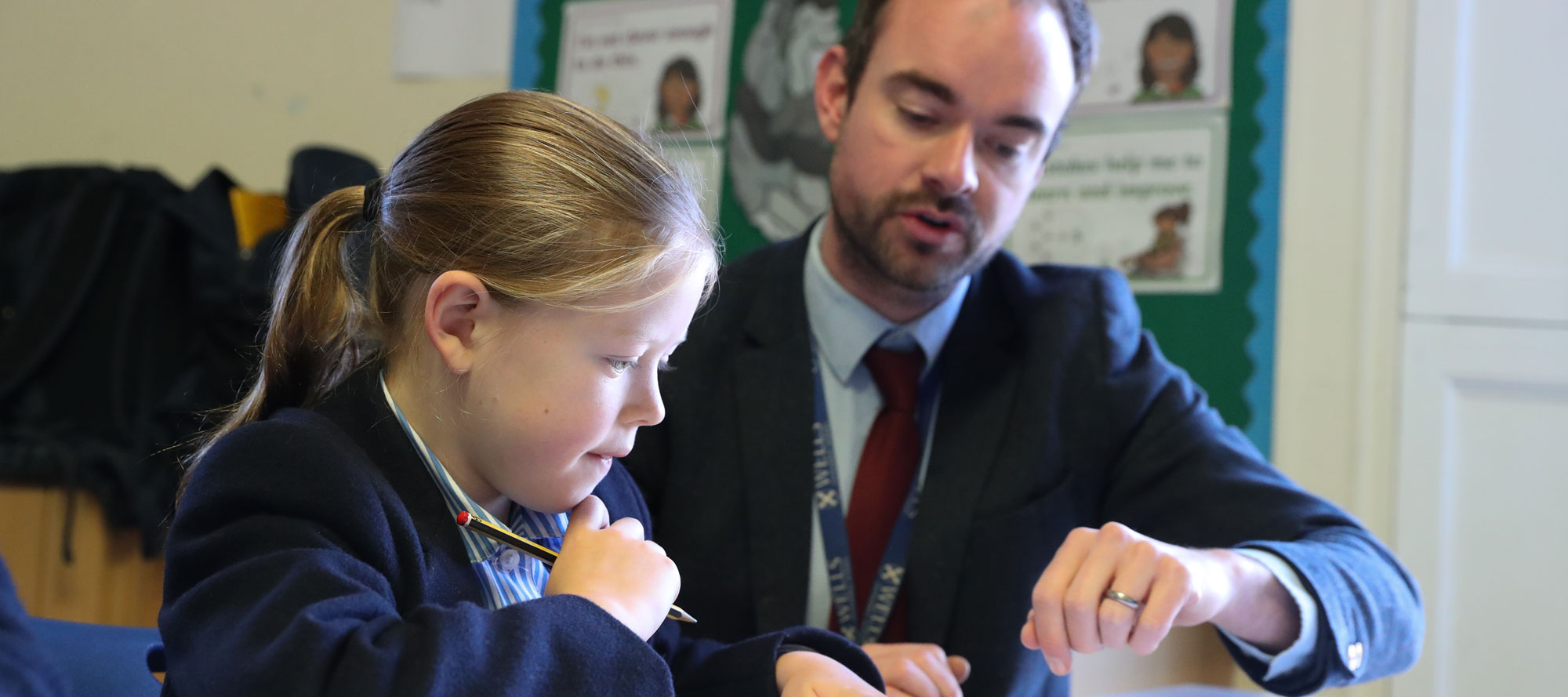 A teacher helping a pupil at maths at Wells Prep School