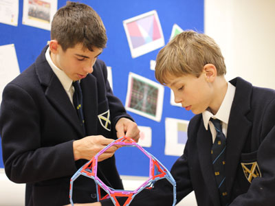 Two specialist mathematicians working on building a shape at our private school in England