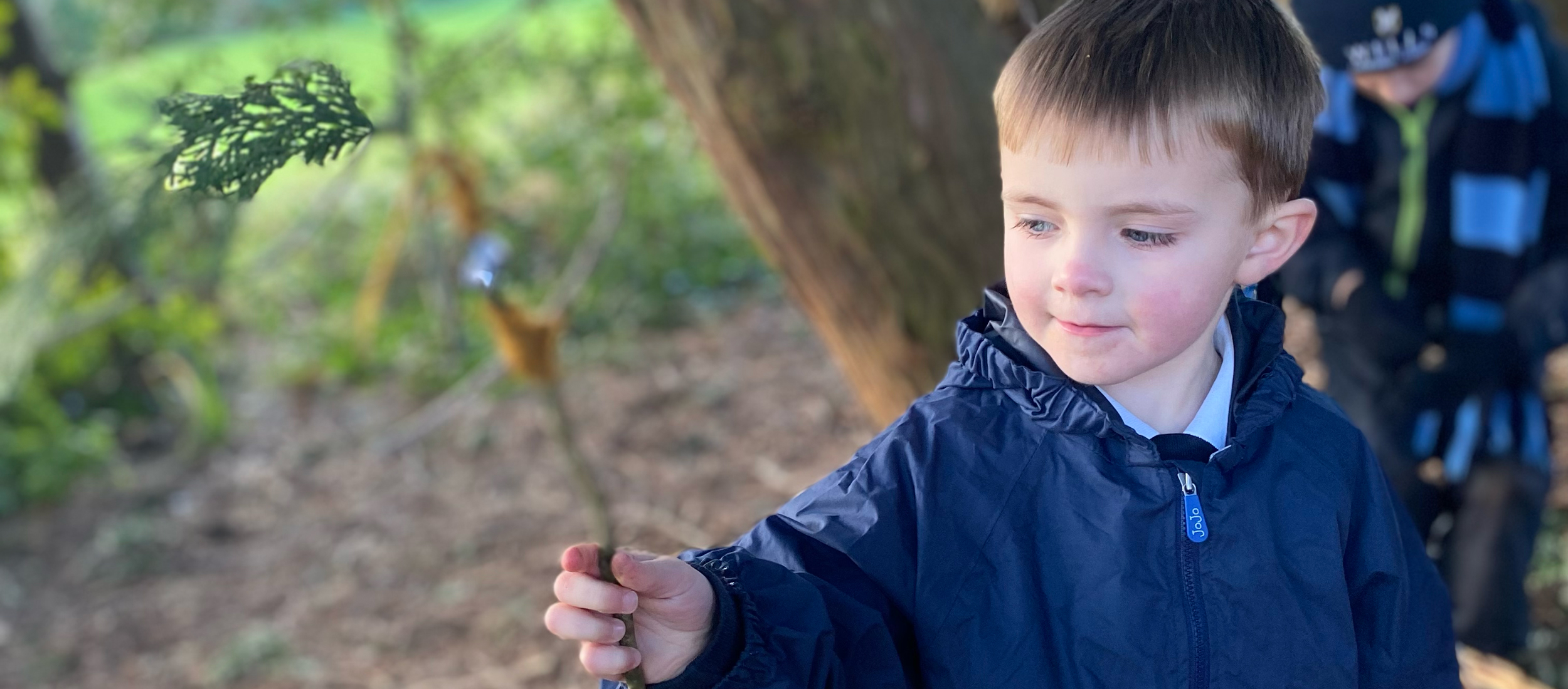 Boy with stick outside at our Independent Pre-Prep in Wells, Somerset