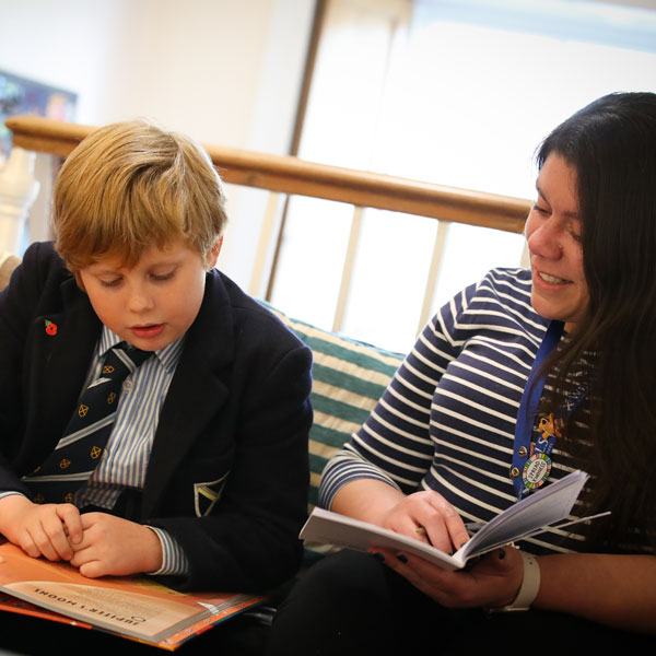 Teacher reading with pupil at our Independent Prep School in Wells Somerset