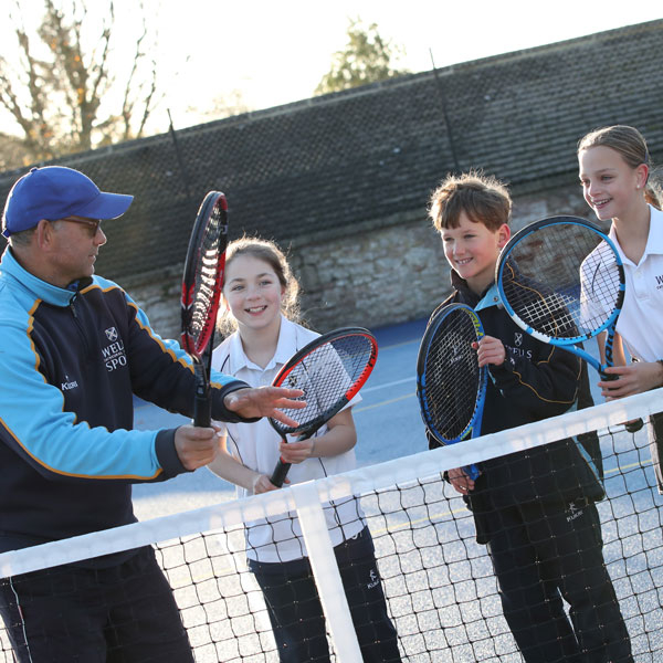 Teacher helping pupils with tennis at our Independent Prep School in Wells Somerset