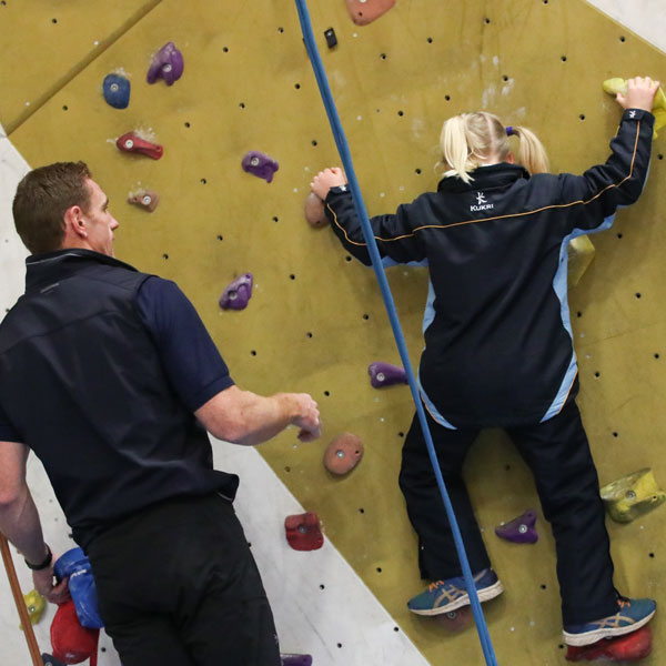 Teacher helping pupils on climbing wall at our Independent Prep School in Wells Somerset