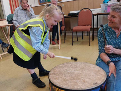 Child playing music at a dementia singing group